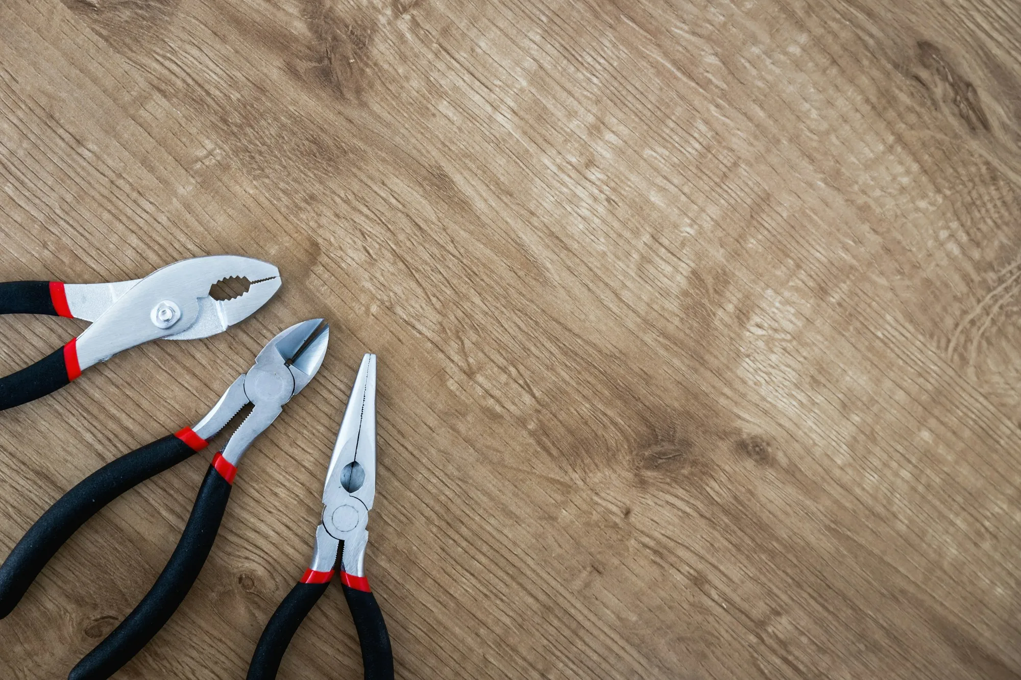 Pair of pliers resting on a wooden surface